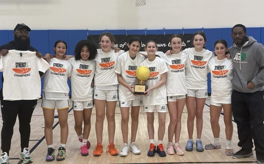 Girls basketball team smiling with their coaches