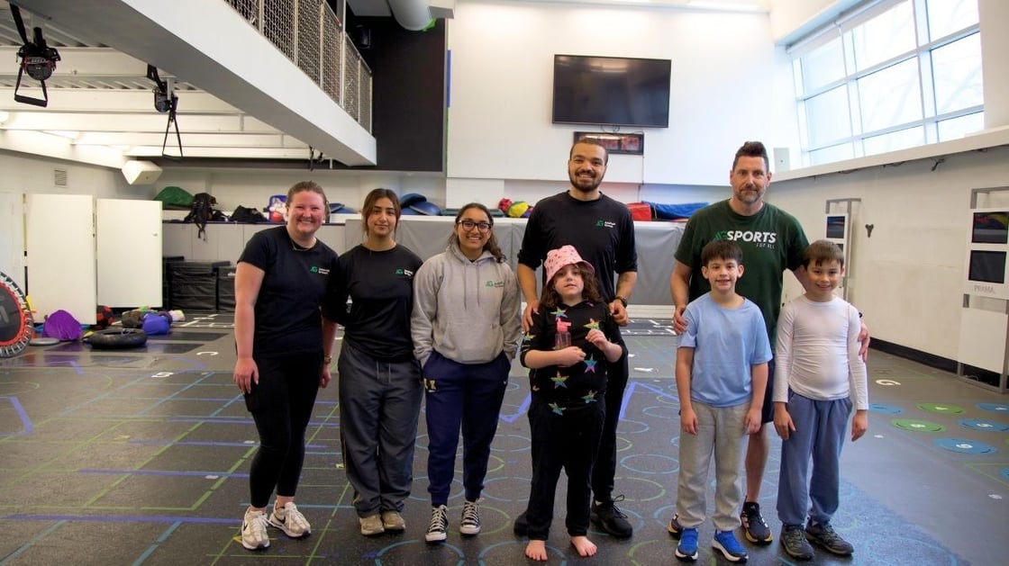 Asphalt Green's Inclusive Programs coaches posing for a photo with their class participants.