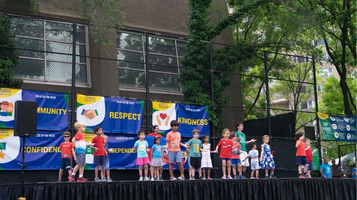 Children dancing and laughing during a Summer Day Camp activity.