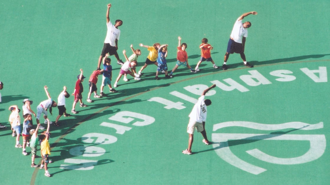 A group of kids and Asphalt Green staff stretching on Litwin Field in the early 2000s.