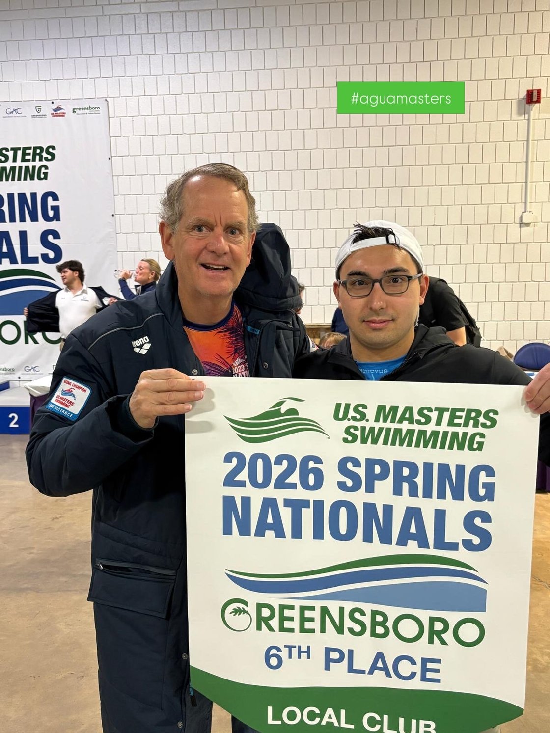 Two people holding a poster that reads, "U.S. Masters Swimming 2026 Spring Nationals".